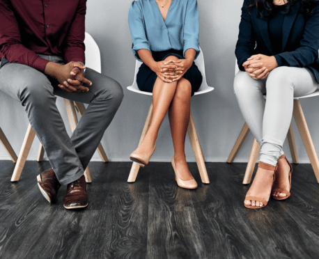 three professionals sitting in chairs from the neck down