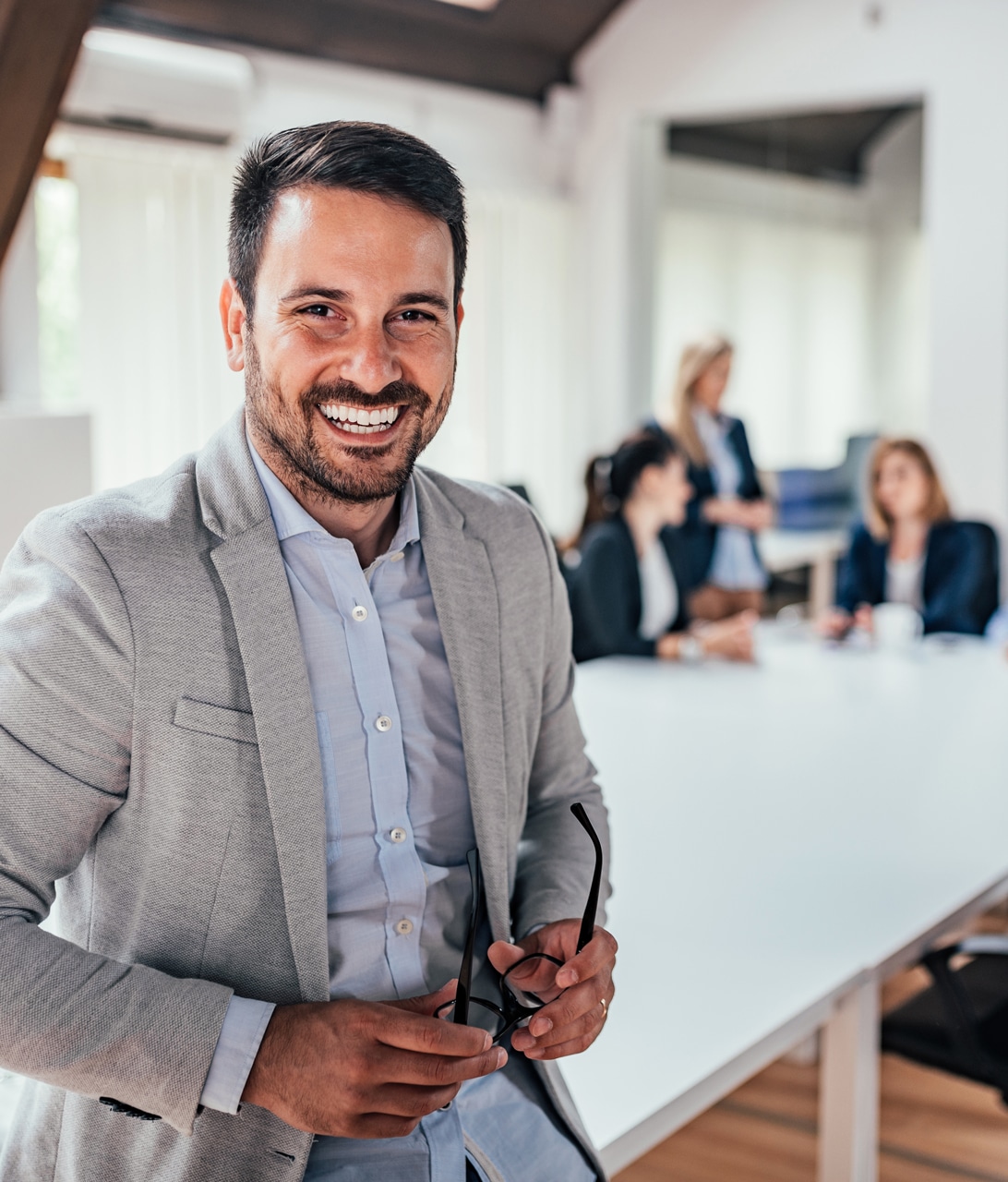 professional man standing in front of team working at a conference room table