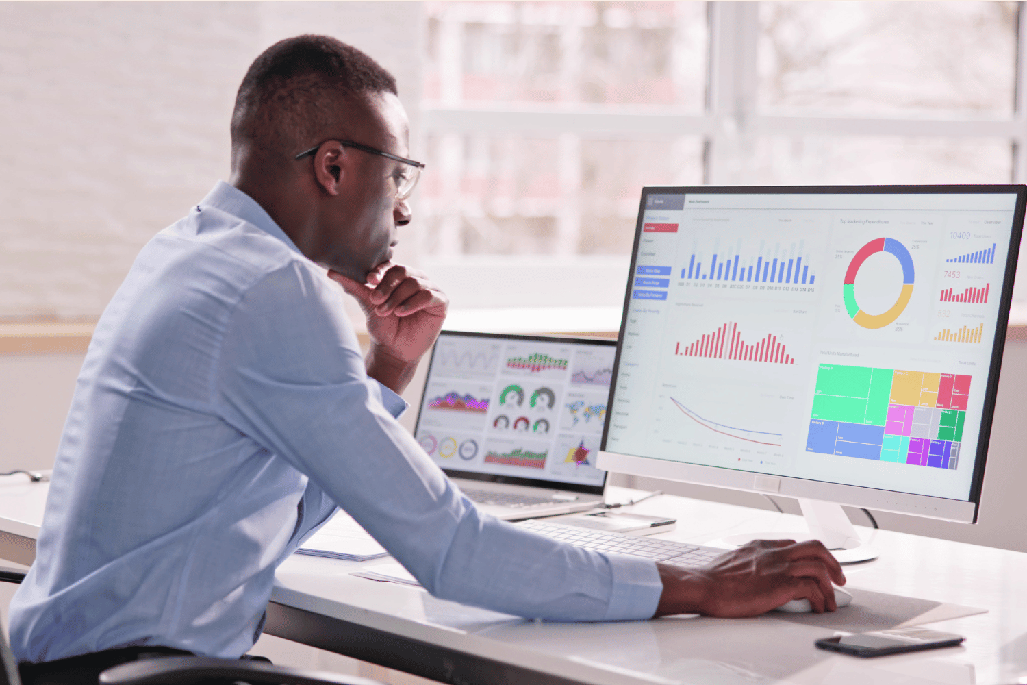 Man working on accounting dashboard on computer in remote office