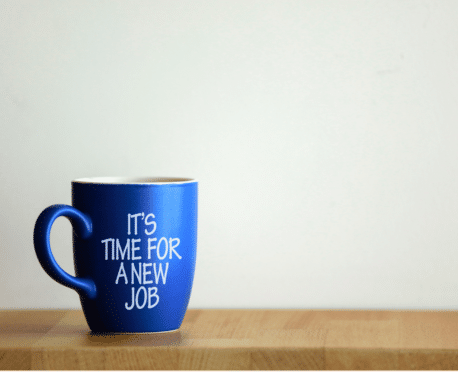 Blue coffee cup on table that says "It's time for a new job"