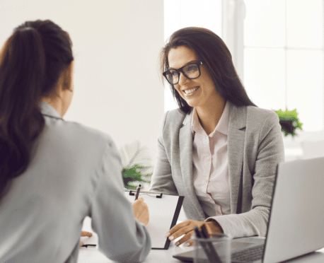 two professional women talking across a desk