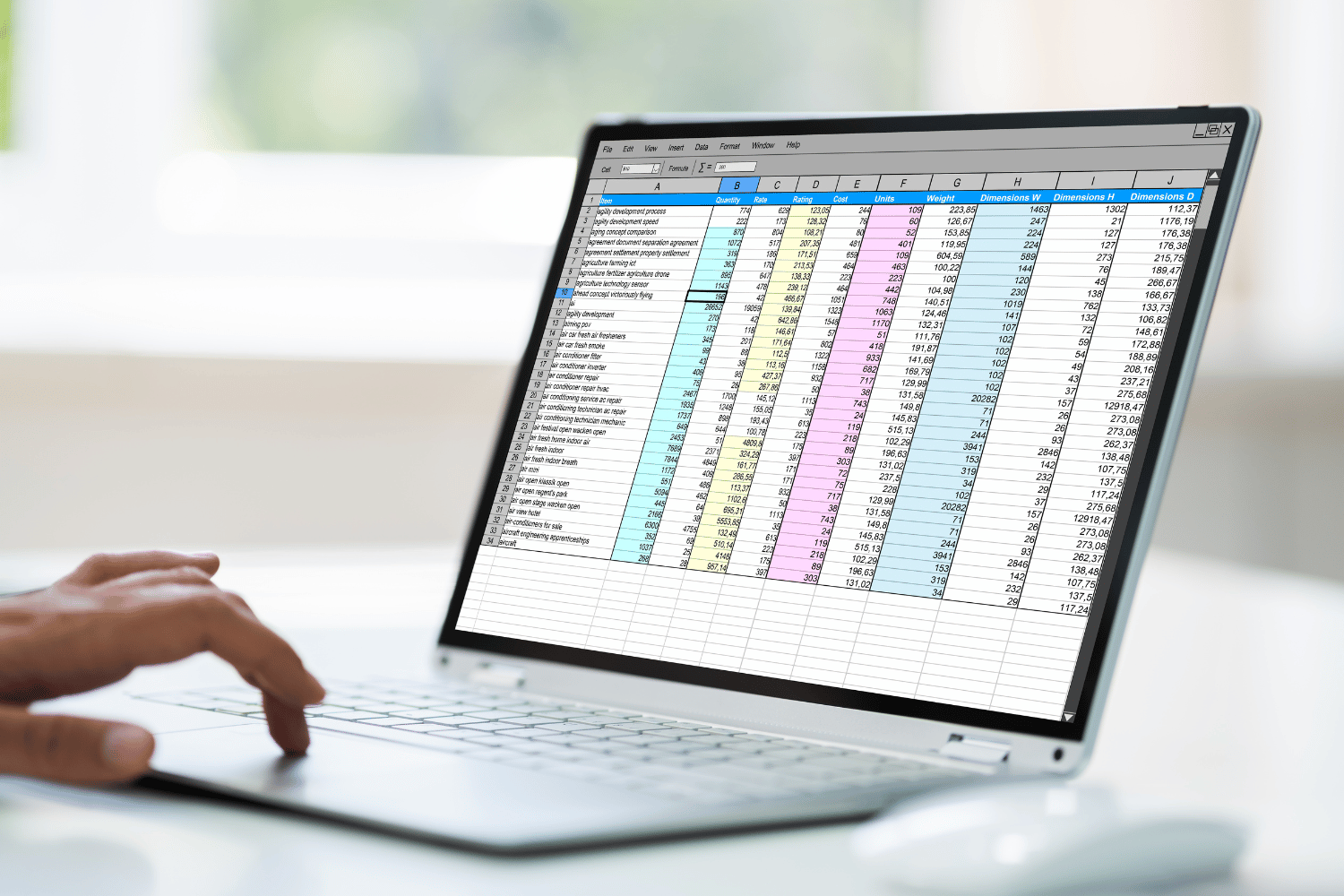 Hand on touchpad of laptop computer with colorful financial spreadsheet on screen