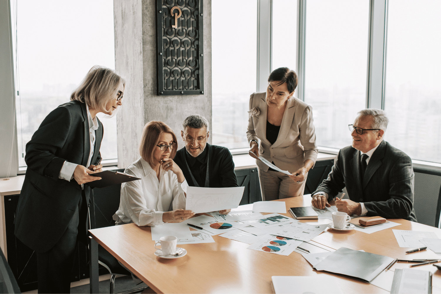 Group of executives gathered around a conference room table, reviewing an important document
