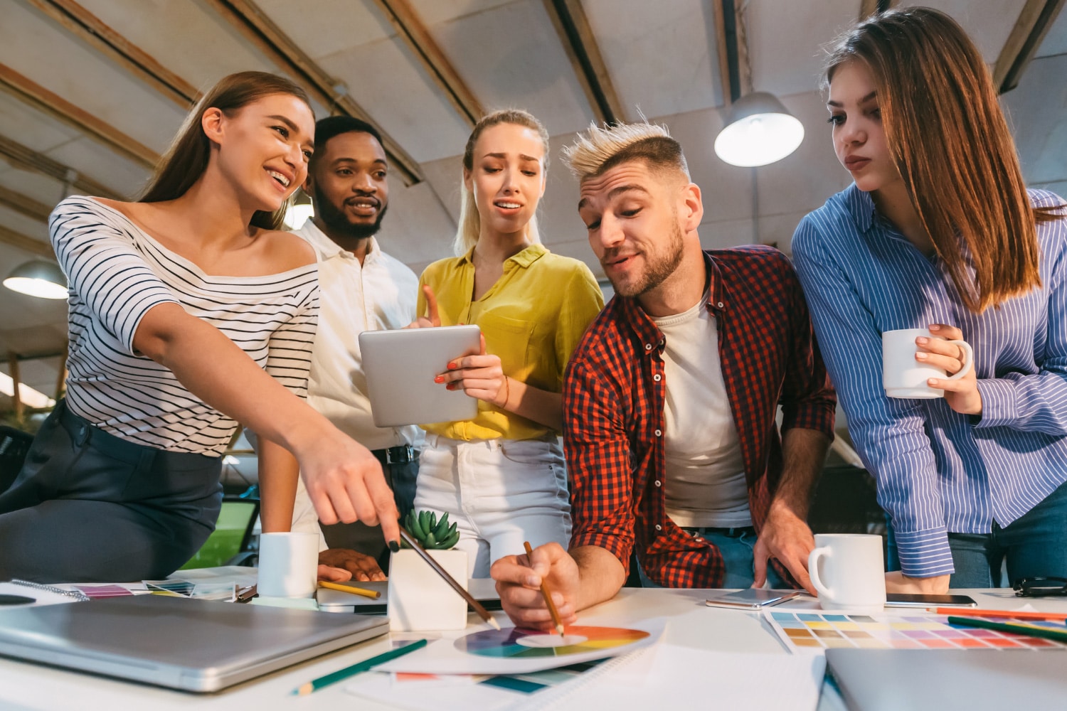 team of young marketing professionals around a desk working on a color wheel