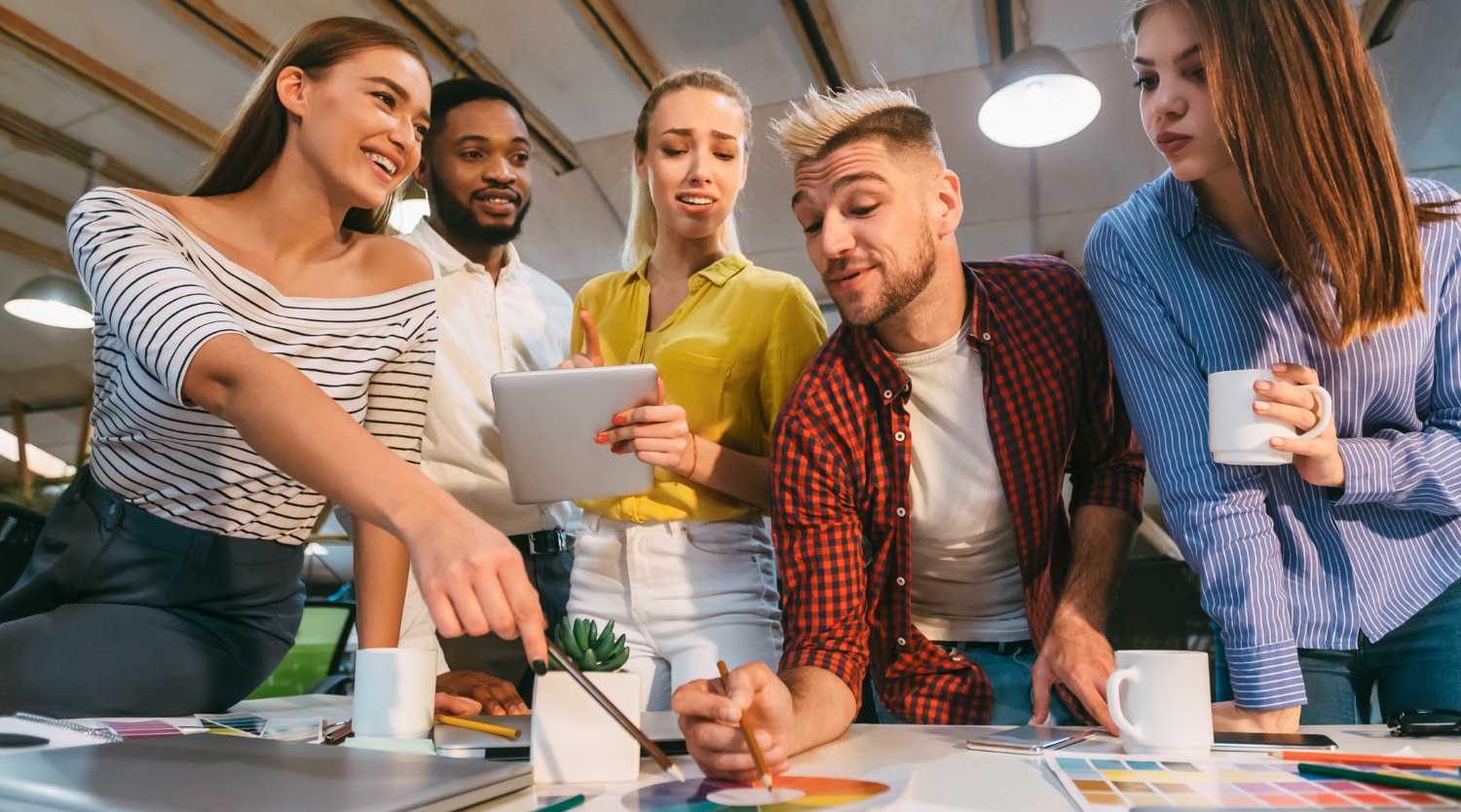 team of young marketing professionals around a desk working on a color wheel