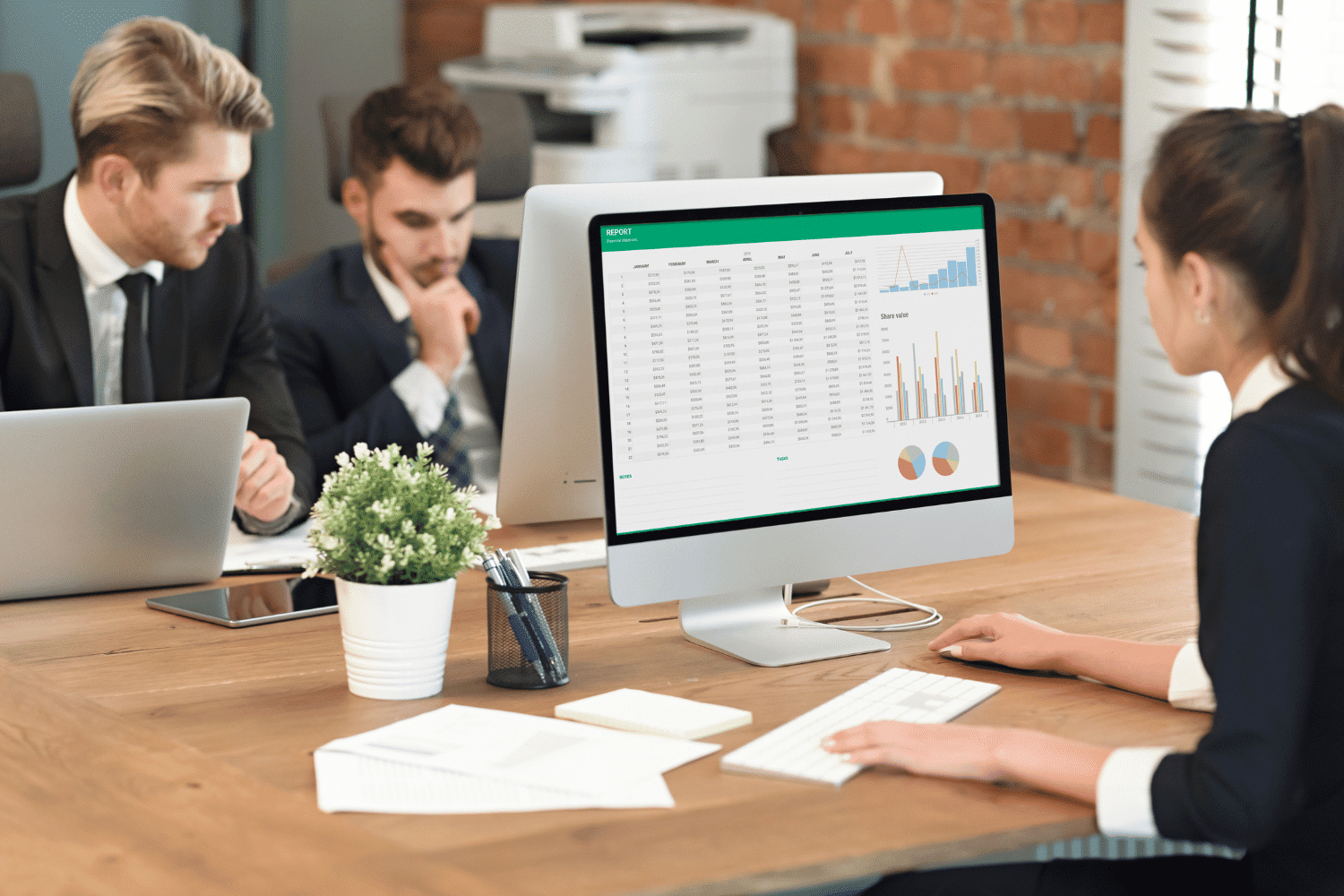 Team of accountants working on computers across shared table