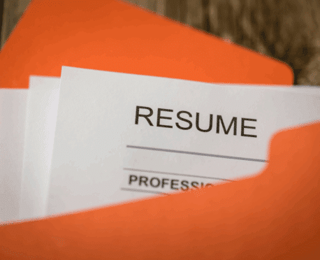 Oranve file folder with papers marked "resume" inside
