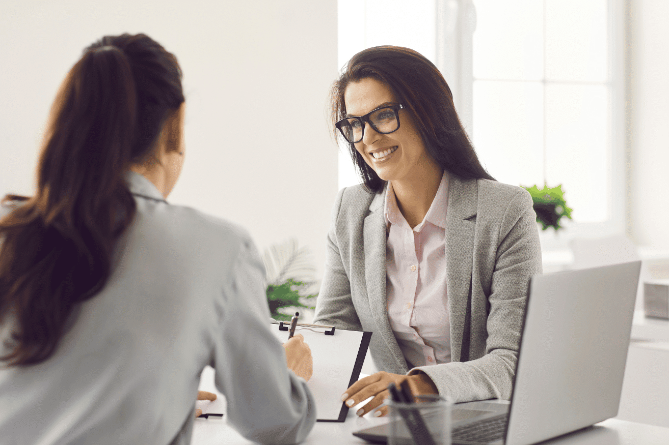 two professional women talking across a desk