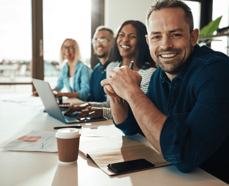 Group of happy professionals working at a conference table together in a great place to work