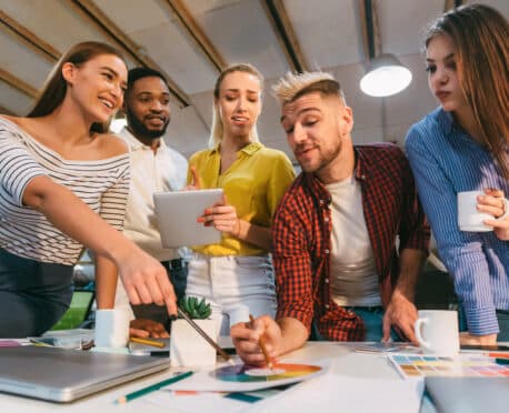 team of young marketing professionals around a desk working on a color wheel