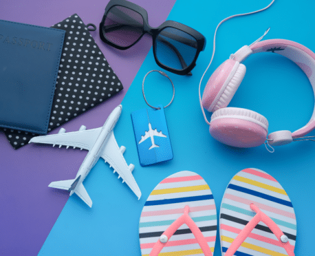 summer vacation travel items on purple and blue background