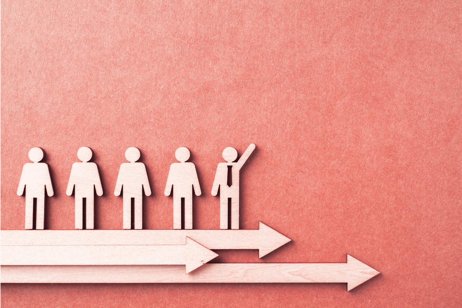 Conceptual image of a leadership pipeline development process featuring wooden cutouts on directional arrows. The highlighted figure symbolizes a high-potential leader identified by Oggi Talent's executive search partners for succession planning.