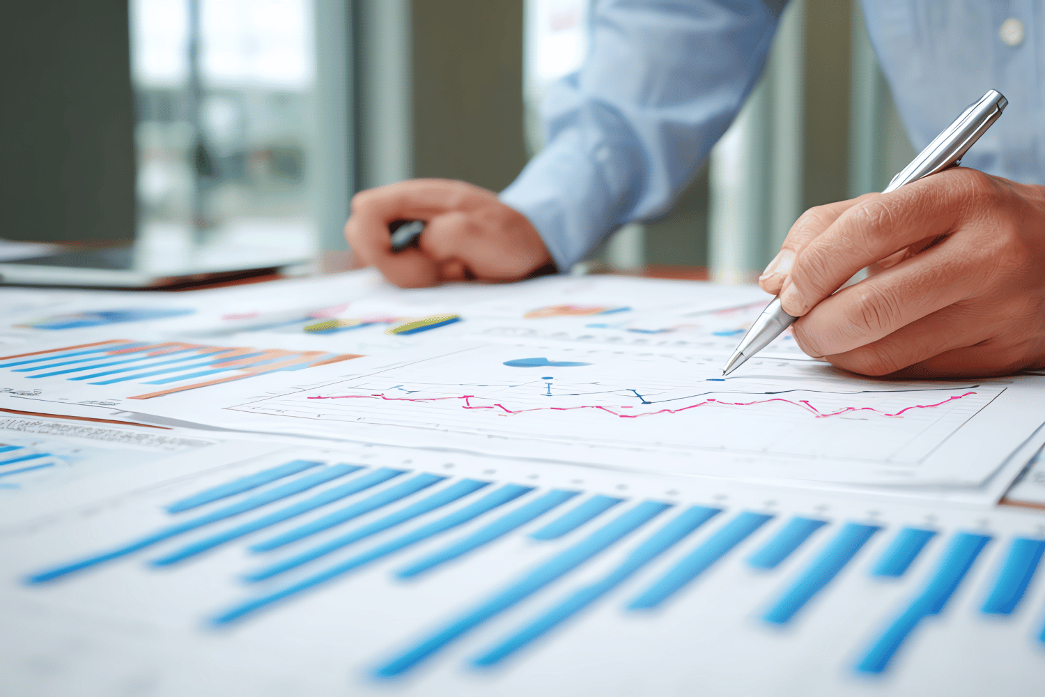 Strategic analysis in action: a hand using a pen over complex financial data charts, conceptualizing the critical analytical capability prioritized by Oggi Talent for skills-first CFO hiring during a competitive talent shortage.