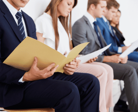 Business professionals seated in a hiring interview or assessment process, illustrating leadership bench strength and executive succession planning.
