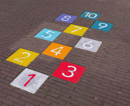 Colorful hopscotch path on brick pavement symbolizing job hopping, career progression, and executive candidate evaluation